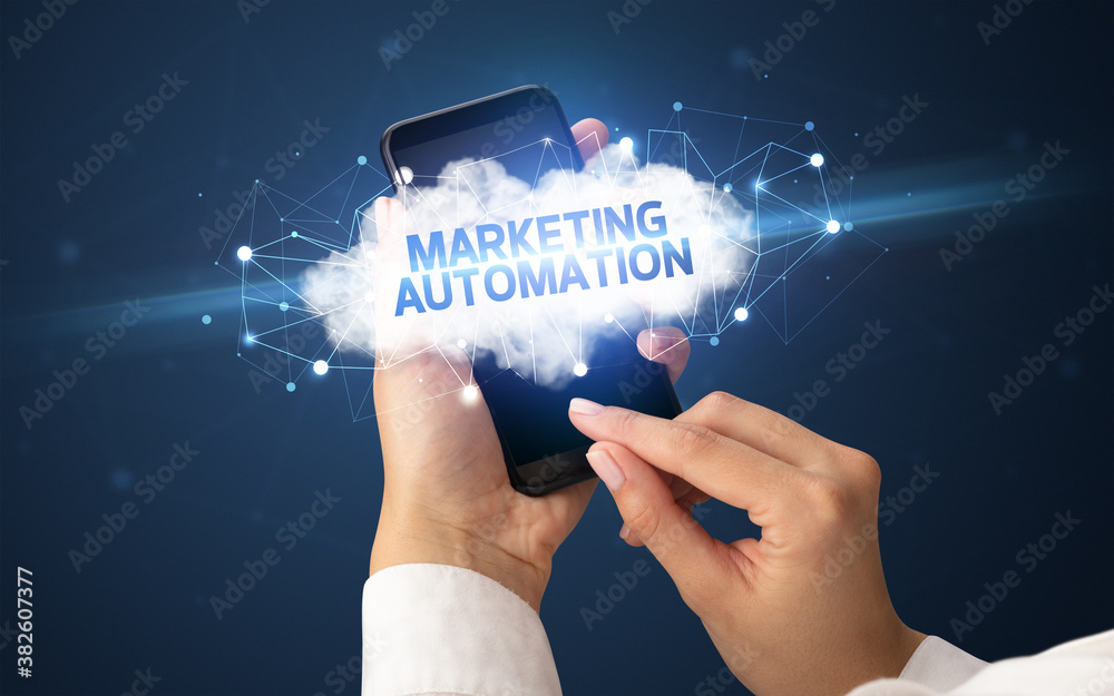 Female hand touching smartphone with MARKETING AUTOMATION inscription, cloud business concept Female hand touching smartphone with MARKETING AUTOMATION inscription, cloud business concept