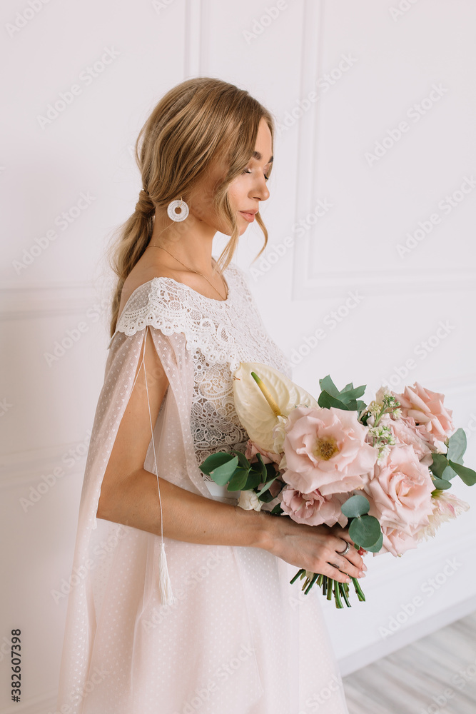 young woman in white wedding dress with long hair before the engagement ceremony with a bouquet of flowers on a white background with a model appearance roses blue eyes young woman in white wedding dress with long hair before the engagement ceremony with a bouquet of flowers on a white background with a model appearance roses blue eyes