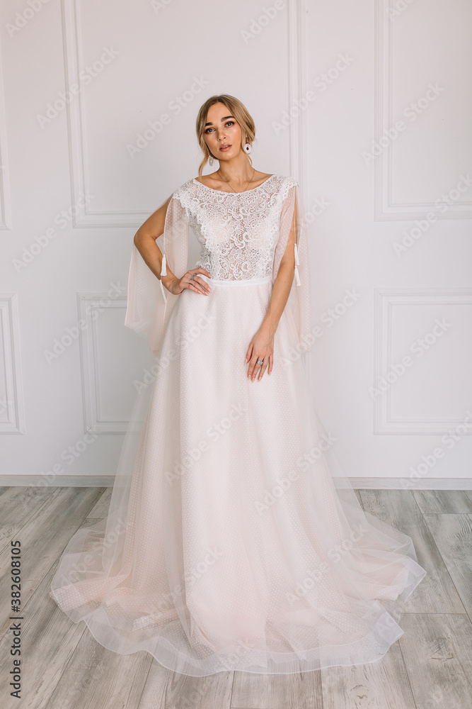 young woman in a white wedding dress with long hair before the engagement ceremony on a white background with a model appearance important wife for the bride posing in front of the photographer
young woman in a white wedding dress with long hair before the engagement ceremony on a white background with a model appearance important wife for the bride posing in front of the photographer