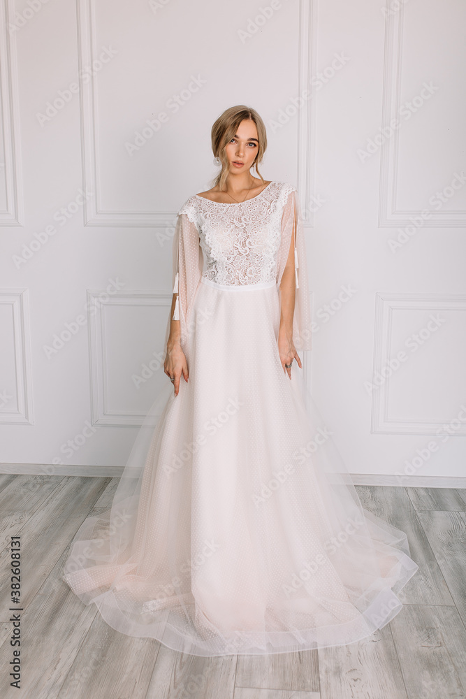 young woman in a white wedding dress with long hair before the engagement ceremony on a white background with a model appearance important wife for the bride posing in front of the photographer
young woman in a white wedding dress with long hair before the engagement ceremony on a white background with a model appearance important wife for the bride posing in front of the photographer