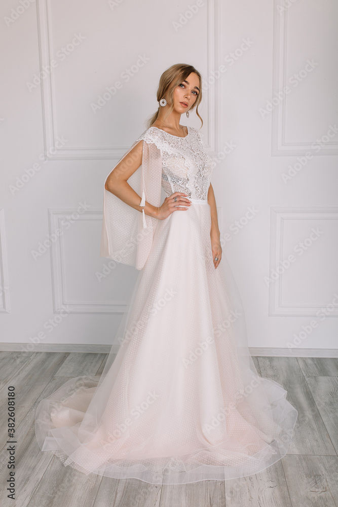 young woman in a white wedding dress with long hair before the engagement ceremony on a white background with a model appearance important wife for the bride posing in front of the photographer
young woman in a white wedding dress with long hair before the engagement ceremony on a white background with a model appearance important wife for the bride posing in front of the photographer