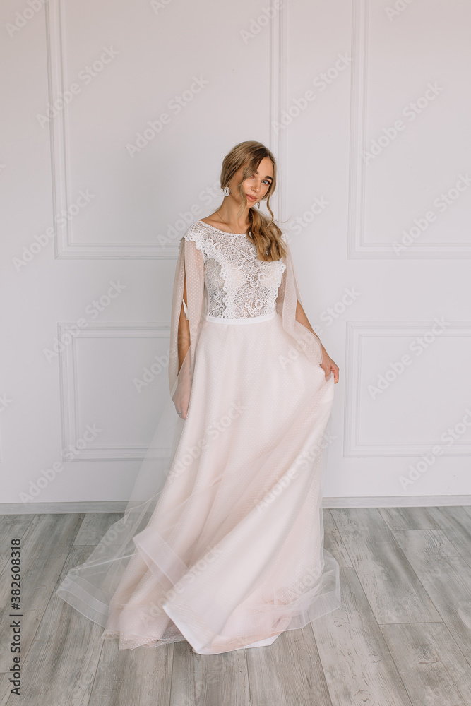 young woman in a white wedding dress with long hair before the engagement ceremony on a white background with a model appearance important wife for the bride posing in front of the photographer
young woman in a white wedding dress with long hair before the engagement ceremony on a white background with a model appearance important wife for the bride posing in front of the photographer