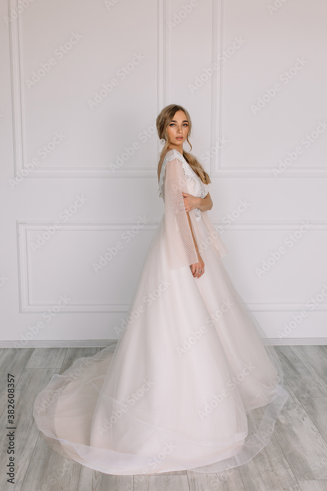 young woman in a white wedding dress with long hair before the engagement ceremony on a white background with a model appearance important wife for the bride posing in front of the photographer
young woman in a white wedding dress with long hair before the engagement ceremony on a white background with a model appearance important wife for the bride posing in front of the photographer