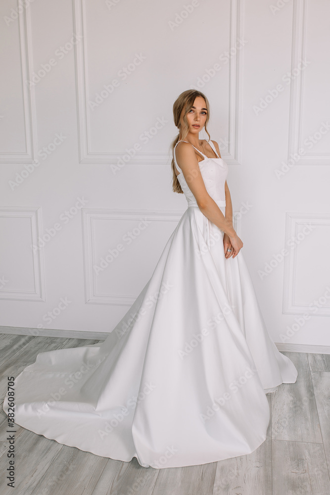 young woman in a white wedding dress with long hair before the engagement ceremony on a white background with a model appearance important wife for the bride posing in front of the photographer
young woman in a white wedding dress with long hair before the engagement ceremony on a white background with a model appearance important wife for the bride posing in front of the photographer