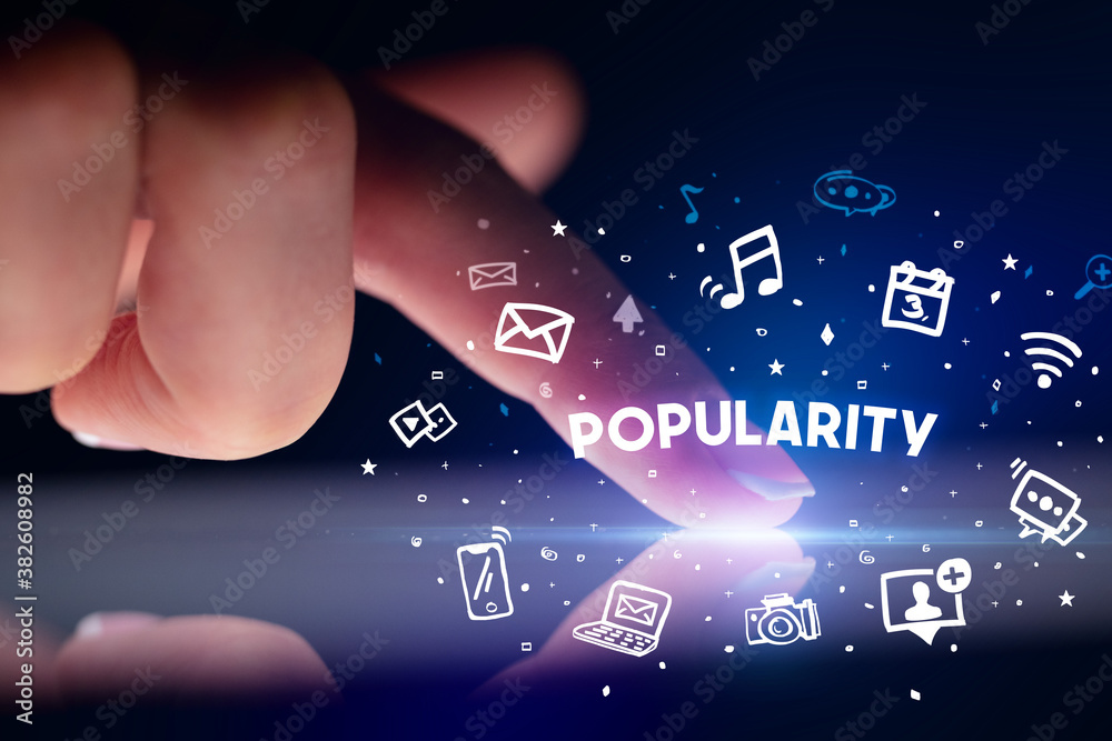 Finger touching tablet with drawn social media icons and POPULARITY inscription, social networking concept Finger touching tablet with drawn social media icons and POPULARITY inscription, social networking concept