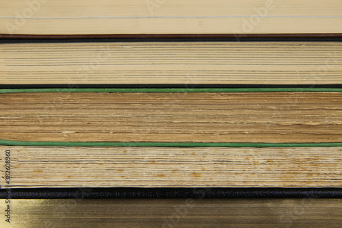 Obraz na plátne View on fore edge of isolated stacked old yellowed books with copy space for tex