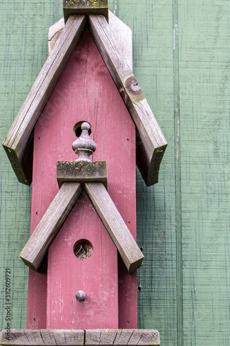 Rustic red barn wood birdhouse in vertical orientaion.  photo