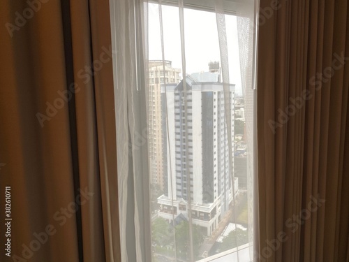 Glimpse of Bangkok city through hotel curtain window