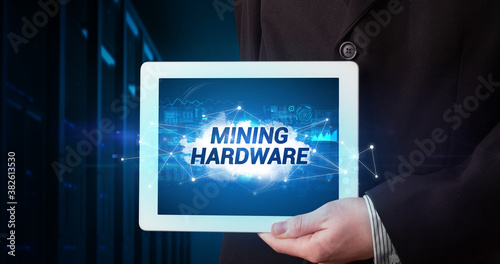 Wallpaper Mural Young business person working on tablet and shows the inscription: MINING HARDWARE Torontodigital.ca