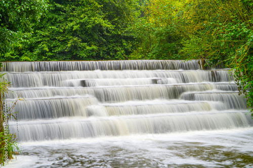 White Water flowing over weir low-level view at long exposure to give blurred motion effects