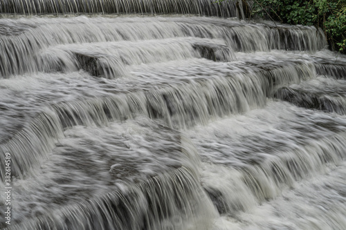 White Water flowing over weir low-level view at long exposure to give blurred motion effect