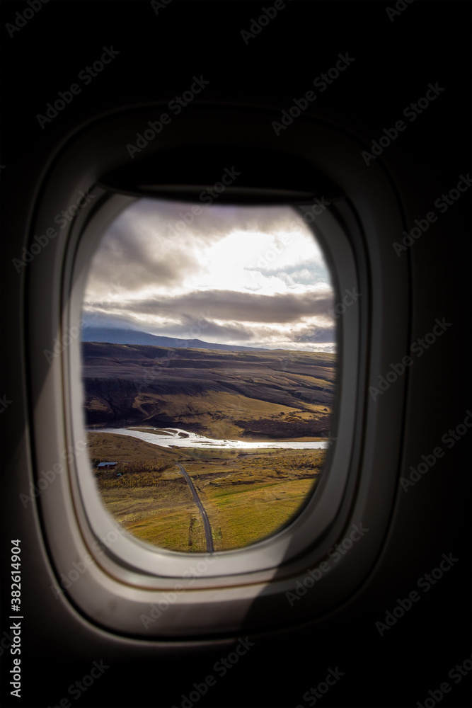 Airplane interior with window view of the highlands of Iceland. Concept of travel and air transportation