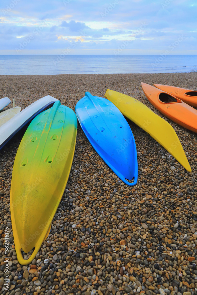 Colourful kayaks on the pebbles beach near village of Beer, Devon Colourful kayaks on the pebbles beach near village of Beer, Devon