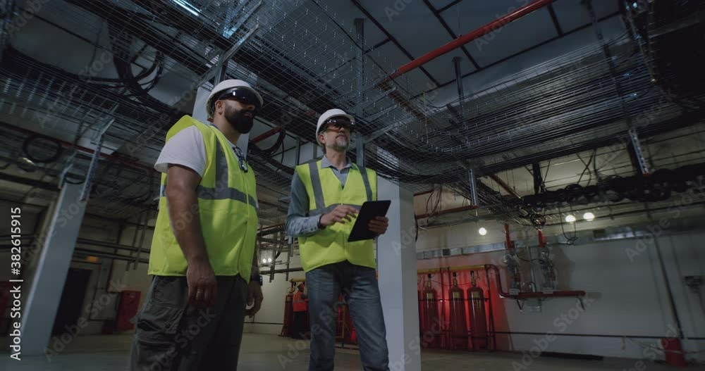 Male builders in goggles examining ceiling