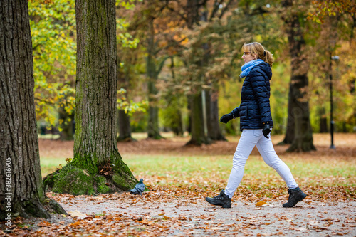 Fototapeta Naklejka Na Ścianę i Meble -  Middle-aged woman walking in city park
