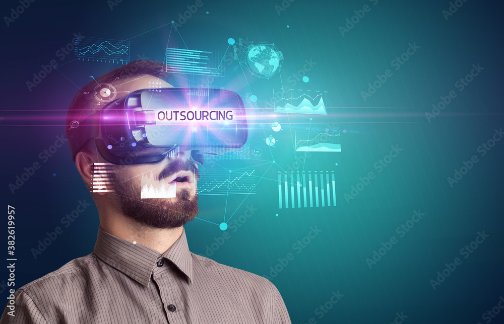 Businessman looking through Virtual Reality glasses with OUTSOURCING inscription, new business concept