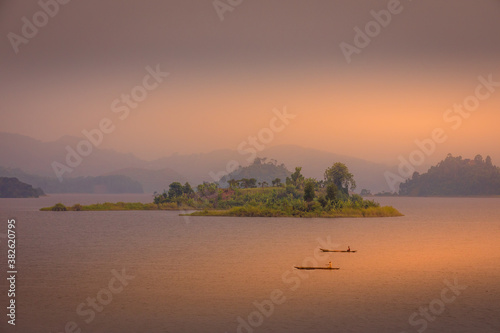 Lake Mutanda at sunset with view on the volcanoes mount Muhavuru and mount Gahinga in East Africa, along the border of Rwanda and Uganda. 