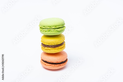 Macaroni of different colors stand one on top of the other in the form of a tower on a white background