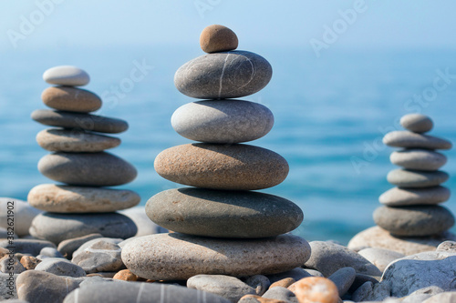 Pyramids of sea pebbles on the beach against the sea on a Sunny day