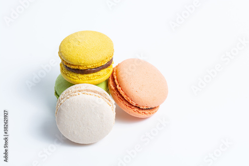 Macaroni, red, yellow, white and green, are stacked one on top of the other on a white background. View from above
