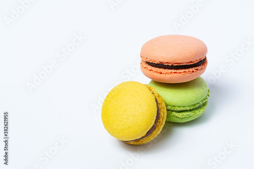 Macaroni, red, yellow and green, are stacked one on top of the other on a white background. View from above
