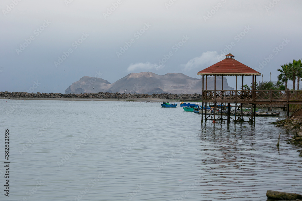 summer house in the middle of the sea with boats and islands in the background. Pacific Ocean in front of Lima.
