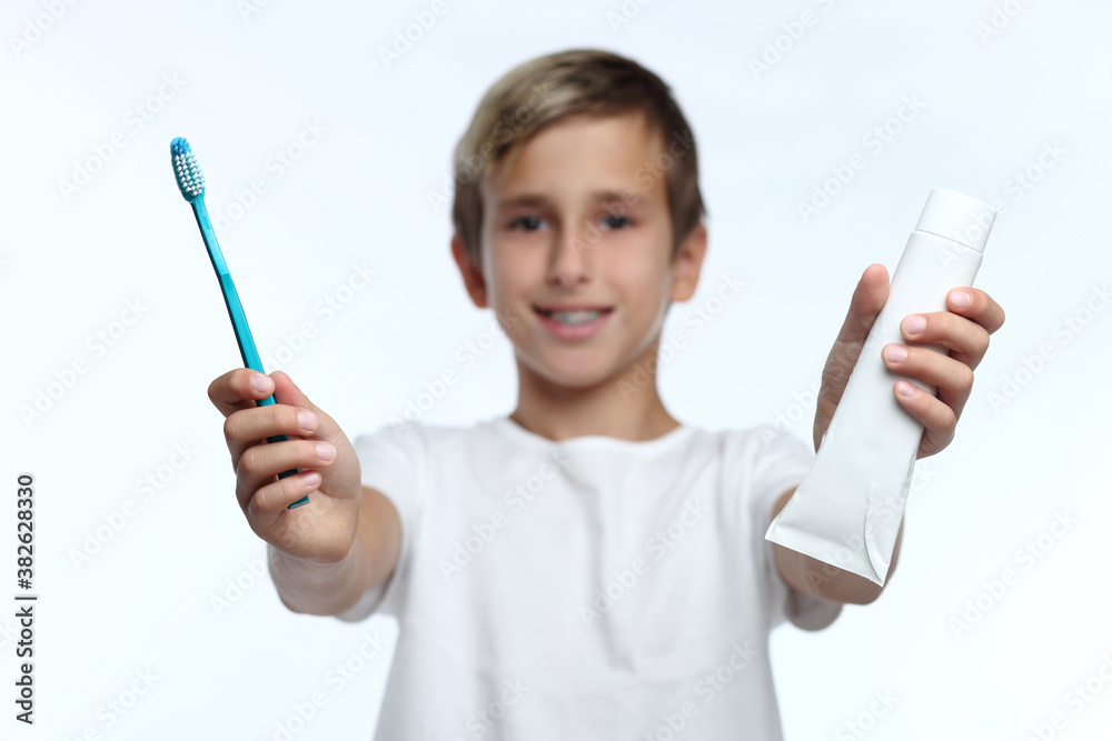 Kid holding toothbrush and putting paste from toothpaste Kid holding toothbrush and putting paste from toothpaste