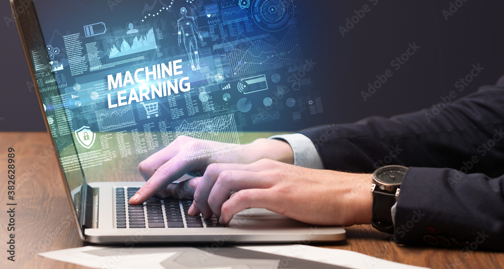 Businessman working on laptop with MACHINE LEARNING inscription, cyber technology concept Businessman working on laptop with MACHINE LEARNING inscription, cyber technology concept
