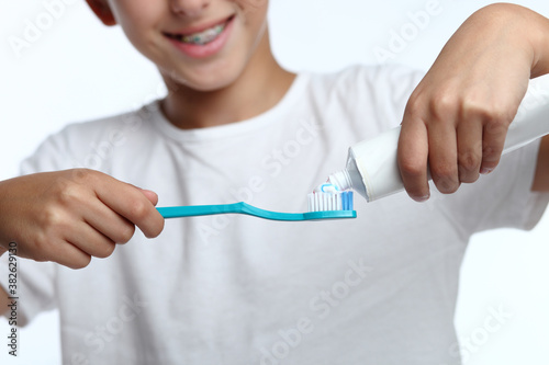 Happy kid taking toothpaste and preparing to brush his teeth with toothbrush