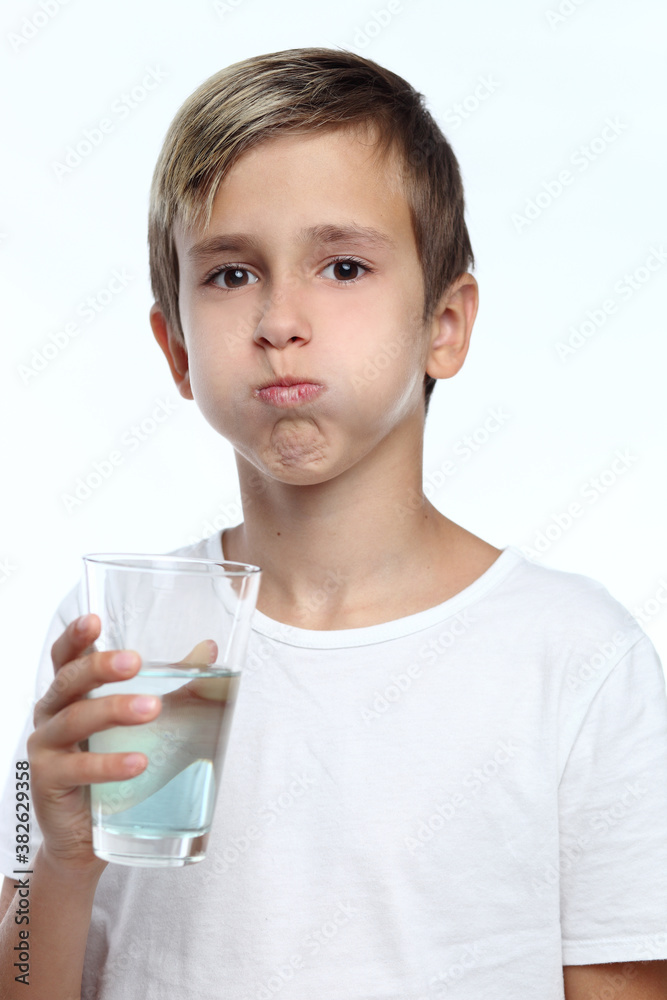Cute boy with white background, wearing braces on his teeth. Spray a disinfectant mouthwash in the throat. Cute boy with white background, wearing braces on his teeth. Spray a disinfectant mouthwash in the throat.