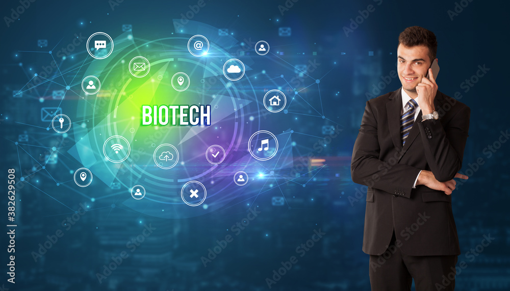 Businessman thinking in front of technology related icons and BIOTECH inscription, modern technology concept Businessman thinking in front of technology related icons and BIOTECH inscription, modern technology concept