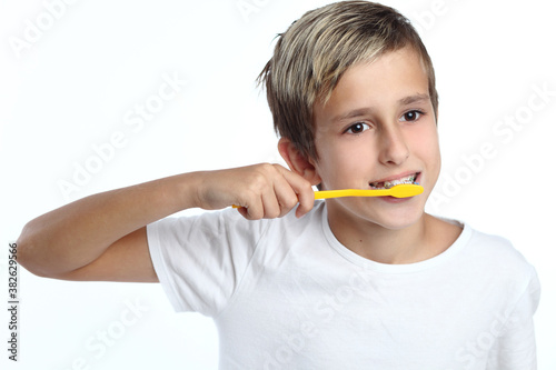 kid smiles while brushing his teeth