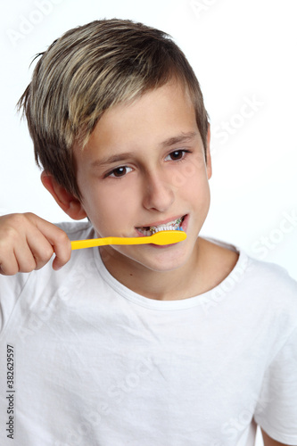 kid smiles while brushing his teeth