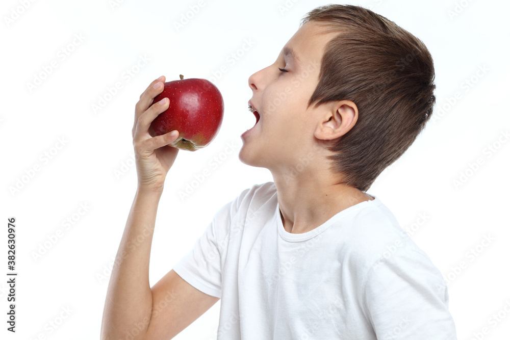 Young boy eating a red apple on a white background Young boy eating a red apple on a white background