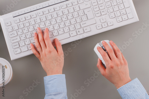 Close up female office manager working on keyboard. Female hands using computer mouse and keyboard. Morning of office worker.