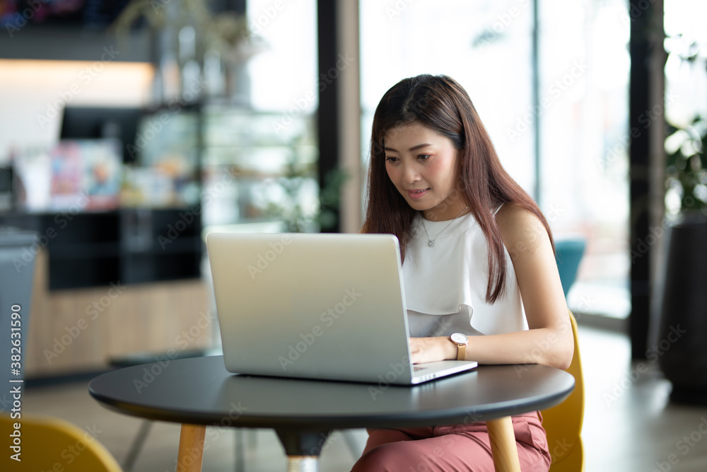 A female accountant hands using and typing on laptop on wooden table in the house A female accountant hands using and typing on laptop on wooden table in the house