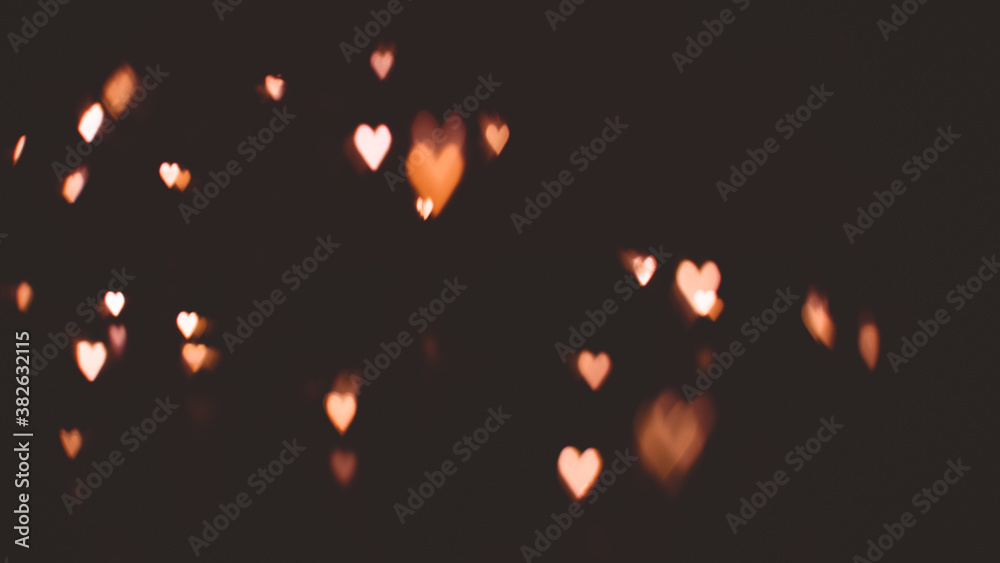 Defocused abstract gold color heart shaped bokeh lights background. orange. valentine's day concept. space for text