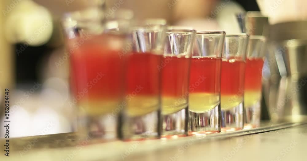 Close up alcoholic shots. The bartender is preparing drinks at the bar. Close up alcoholic shots. The bartender is preparing drinks at the bar.
