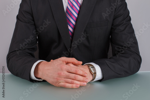 Hands of businessman on the table. Mans hands in business suit on the table. Meeting and deadline concept.
