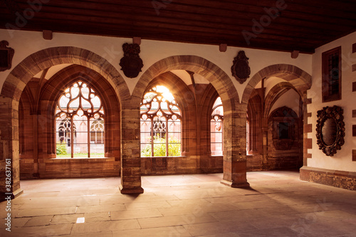 Sunlight in inner cloister, archway with collumns and openwork windows. Cathedral in Basel, Switzerland. photo