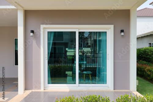 Green clear glass attached to the sliding door and wall of the house.