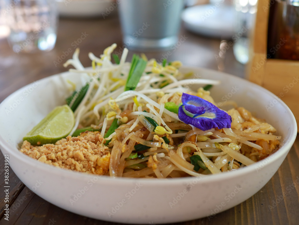 Pad Thai noodles on the table and have butterfly pea flowers Scientific name Clitoria ternatea, put on noodles Pad Thai noodles on the table and have butterfly pea flowers Scientific name Clitoria ternatea, put on noodles