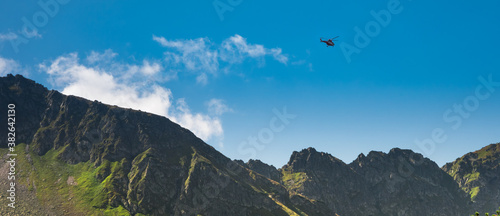 Red helicopter of TOPR (Polish mountain rescue team) during emergency action in Tatra mountains photo