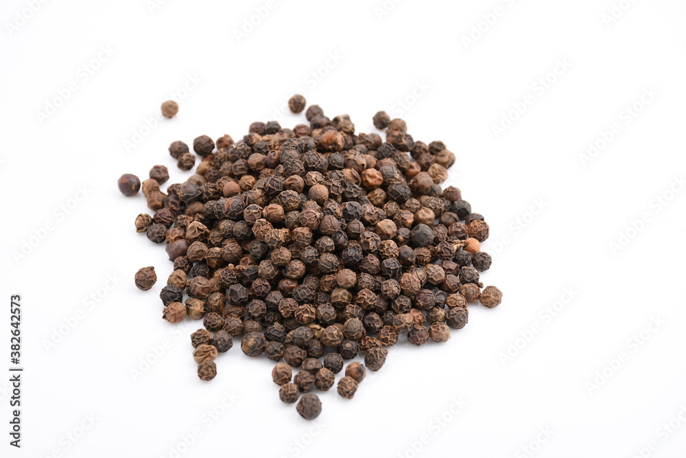 A molehill of a handful of black pepper scattered on a plain while background. A molehill of a handful of black pepper scattered on a plain while background.