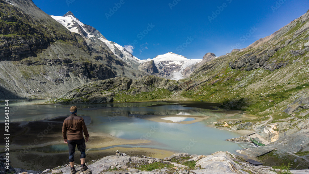 Hiker views Europe top 10 best hiking trails with glacier and alpine lake with crystal clear blue lake and sky Hiker views Europe top 10 best hiking trails with glacier and alpine lake with crystal clear blue lake and sky