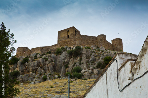 Castillo fortaleza en colina de roca gris visto desde su base