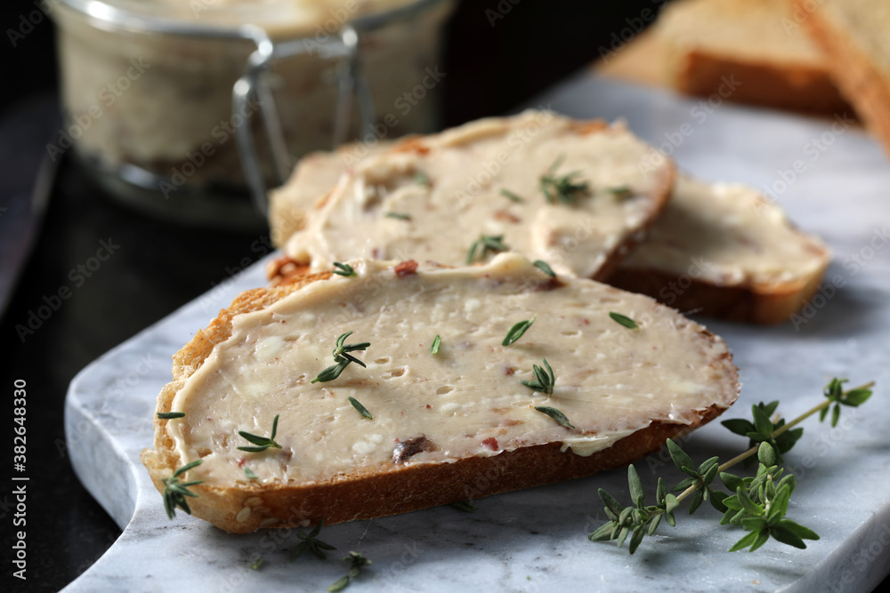 Anchovy butter spread on toast, with anchovy butter jar in the background. Anchovy butter spread on toast, with anchovy butter jar in the background.
