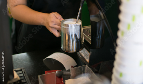 Barista Steaming Milk And Coffee In Coffeeshop © vii