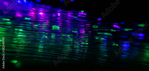 This picture displays colored bottle lights which look like fiber optic cables. The background is black.