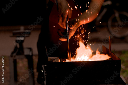 a furnace burning with a bright flame and the hands of a blacksmith with tongs. Fire of blacksmith in the blacksmith's workshop